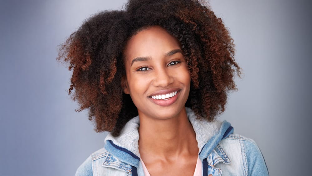 Smiling woman with curly natural hair in a professional acting headshot by Joshua Shelton at Headshots LA in Los Angeles