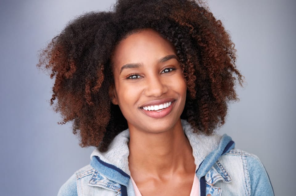 Smiling woman with curly natural hair in a professional acting headshot by Joshua Shelton at Headshots LA in Los Angeles