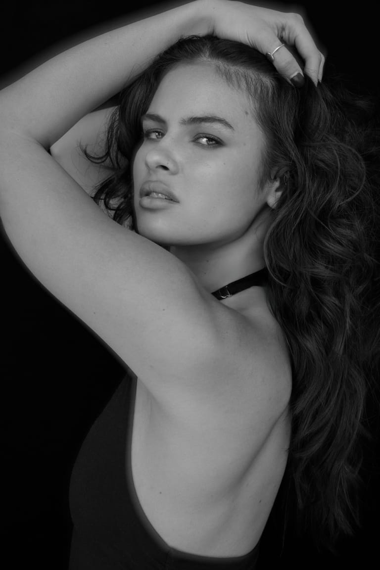 Black and white professional headshot of actress Jay Irwin with soft lighting and a confident expression against a dark background, photographed by Joshua Michael Shelton.