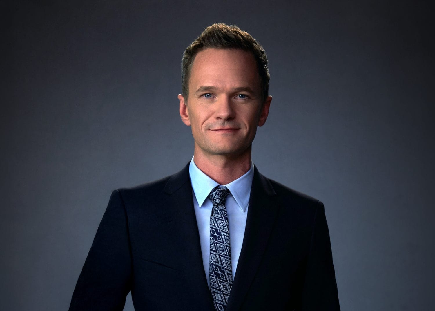 Neil Patrick Harris in a navy suit on a gray studio backdrop — celebrity headshot by Headshots LA in Los Angeles.