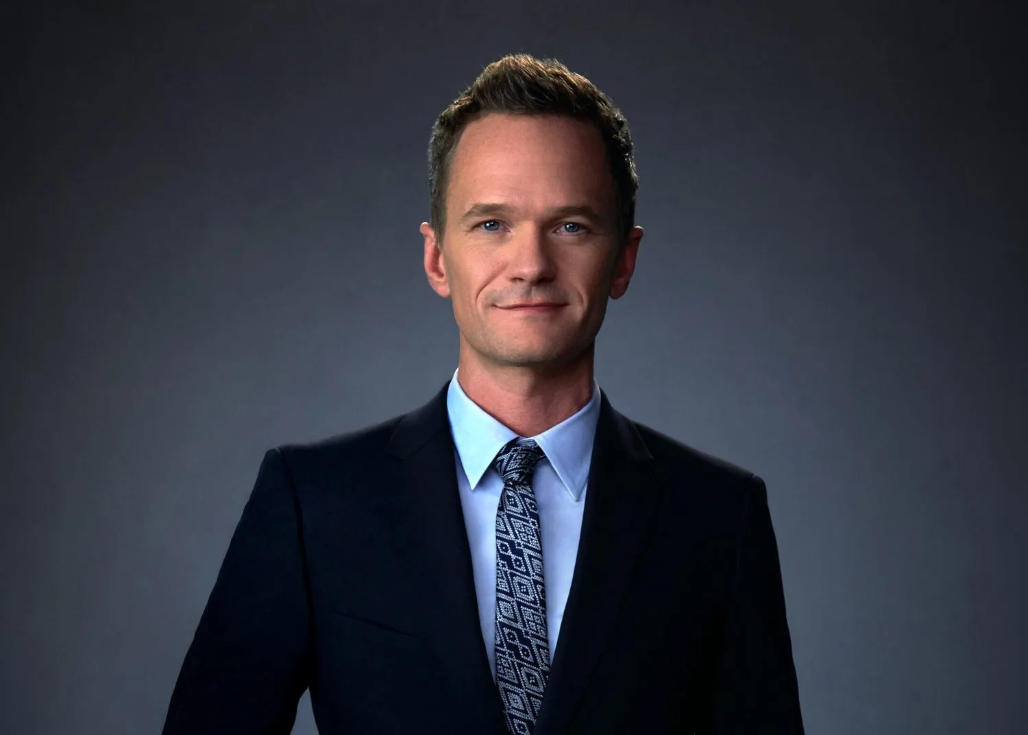 Neil Patrick Harris in a navy suit on a gray studio backdrop - celebrity headshot by Headshots LA in Los Angeles.