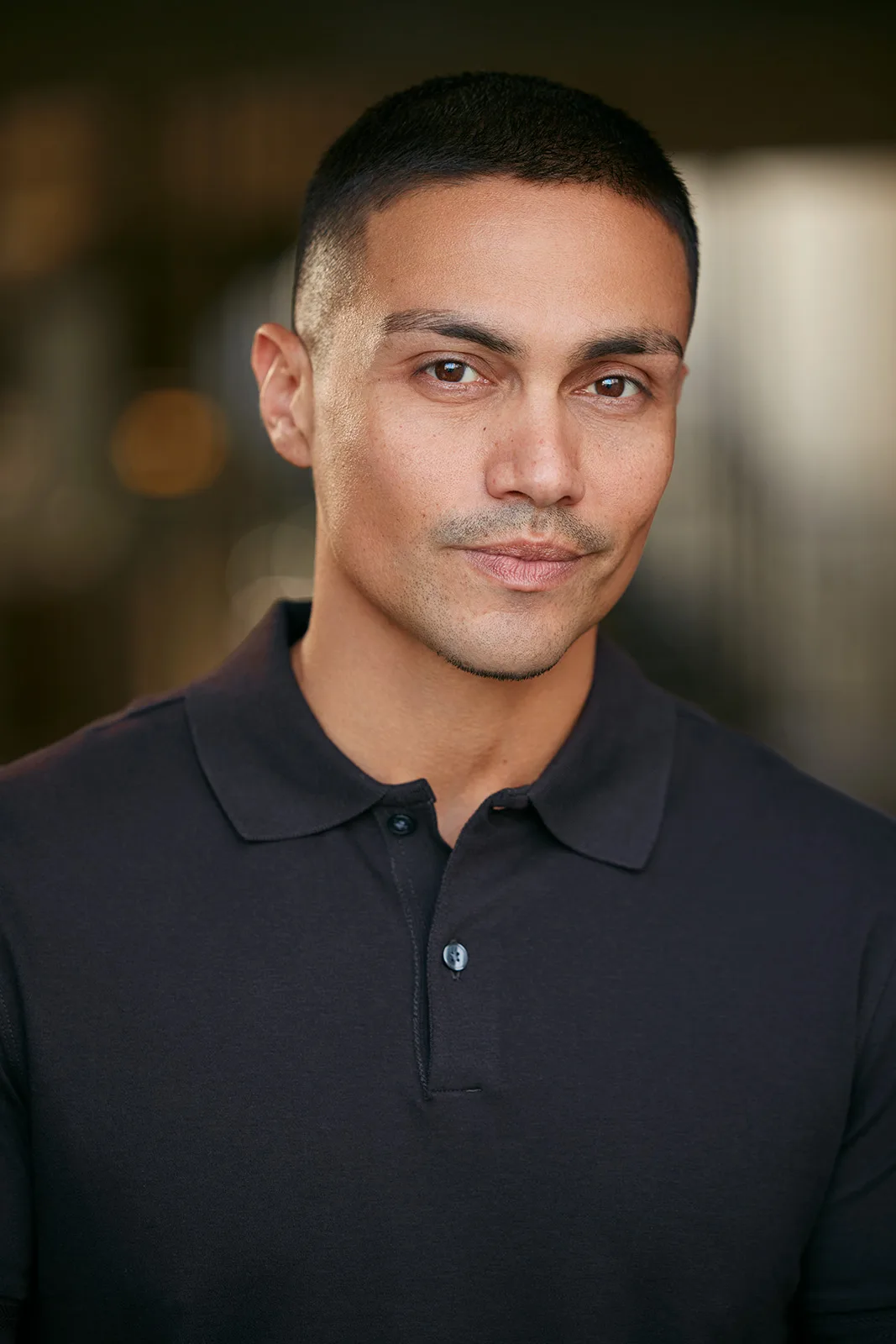 Rene Moran in a charcoal polo on a warm blurred background - celebrity headshot by Headshots LA in Los Angeles.
