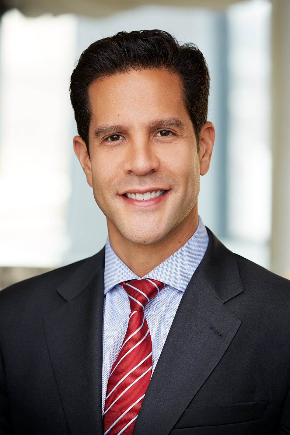 Professional corporate LinkedIn headshot with genuine smile, sharp focus, and clean blurred background